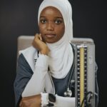 Portrait of a female medical student wearing a hijab, sitting with medical tools.